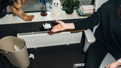 Käsi heittämässä paperia roskakoriin