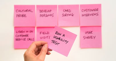 Pinkki post-it lappu ihmisen kädessä tekstillä 