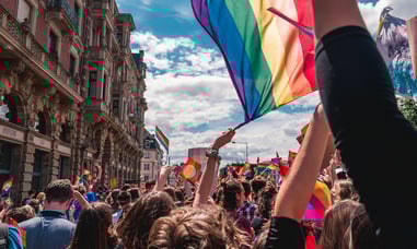 People marching for Pride, a Pride flag being waved